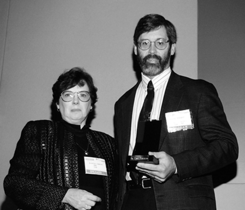 Bonnie Lawlor, presidenta de UMI, hace entrega del premio a Chris Ferguson.